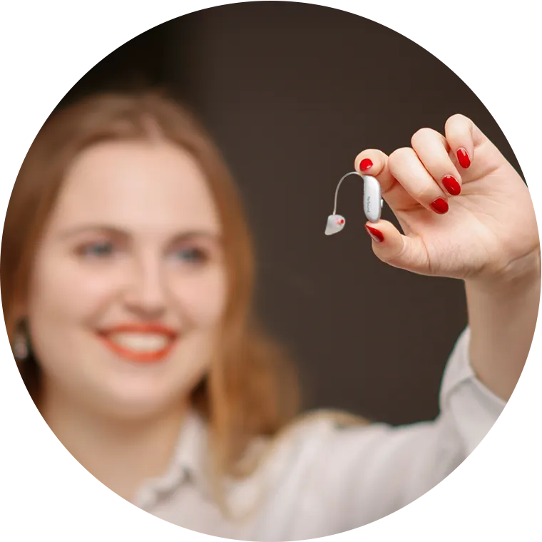 Hörakustikerin mit Hörgerät in der Hand